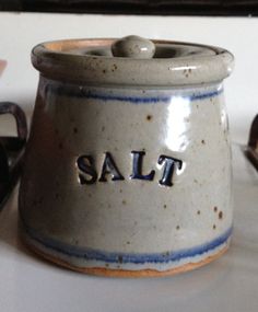 a salt and pepper shaker sitting on top of a counter next to other kitchen utensils