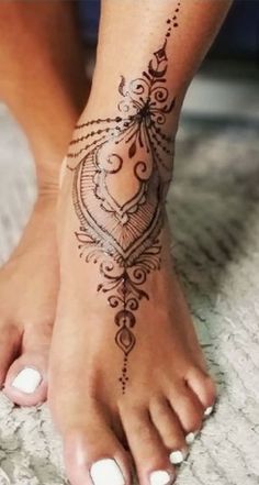 a woman's foot with a henna tattoo on it