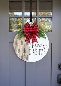 a christmas door hanger with a red bow and merry christmas sign on it's front door