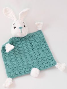 a crocheted bunny laying on top of a blanket