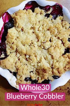 a close up of a plate of food on a table with the words whole 30 blueberry cobbler