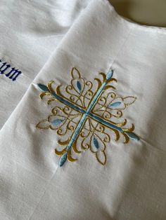 an embroidered cross on a white shirt with blue and gold accents