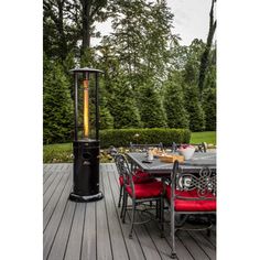 an outdoor patio heater sitting on top of a wooden deck next to a table