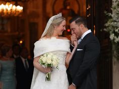 a bride and groom standing in front of an entrance