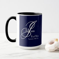 a black and white coffee mug next to a donut