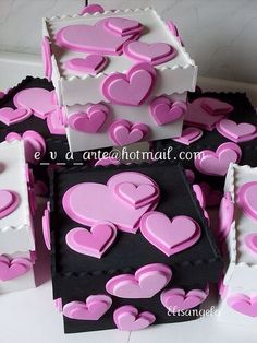 there are many pink hearts on the black and white boxes that look like they have been made out of paper