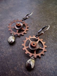 "Steampunk. Modern. Fun. Riveted copper sprockets/gears with sterling silver and pyrite drops.The lever backs are oxidized sterling silver .They are about 1.25\" long." Punk Style Brown Jewelry For Gift, Handmade Brown Steampunk Jewelry, Handmade Steampunk Copper Jewelry, Handmade Copper Steampunk Jewelry, Pyrite Earrings, Hardware Jewelry, Punk Pins, Steampunk Earrings, Punk Earrings