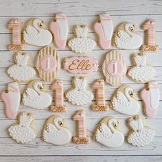 baby shower cookies decorated with pink and white icing are arranged on a wooden table