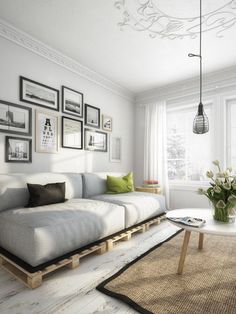 a living room with white furniture and pictures on the wall above it's coffee table