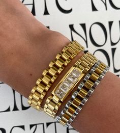 Like a watch but not. Our gorgeous golden Rolly bracelet gives you dressed up or edgy cool girl vibes with our timeless watchband style. 18k gold plated over stainless steel Silver / gold mix Water / tarnish resistant 7'' inch length Pair it with our Rolly ring or gold Rolly bracelet for the perfect stacked look