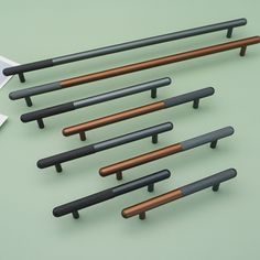 several black and brown wooden handles on a green surface