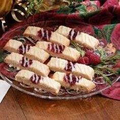 several pieces of cake sitting on top of a glass platter next to some flowers