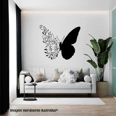 a living room with a white couch and black butterfly wall decal