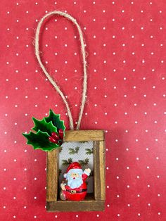 an ornament hanging in a wooden frame on a red background with white polka dots