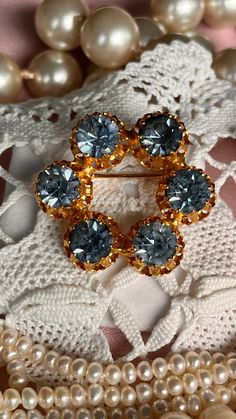 This Vintage 1950's brooch is gold layered in art deco style. It is decorated with 6 blue amazing shiny gemstones. The brooch has a safety mechanism so you will not loose it. This brooch is the ideal wedding gift for the bride to be  something OLDsomething BLUE diameter: 35 mm  Find the ideal wedding gift for the bride or groom to be . Something old ,  Something new , Something borrowed ,  Something blue,  We also have the ideal gift for the birth , babtise of your beloved baby , child or  godchild . Our selection of antique pendants and medallions are the ideal gift , to show her/him your love or give her/him your blessing . But also important is a gift for yourself , yes sometimes we can treat ourself with that unique piece. All items get standard packed in a Beautifull giftbox. If you d Luxury Vintage Brooch For Anniversary, Vintage Blue Brooches For Anniversary, Vintage Sapphire Brooches For Gifts, Vintage Gold Brooches With Cabochon, Vintage Baroque Brooches For Gifts, Gemstone Brooch, Antique Pendant, Something Old, Ideal Wedding