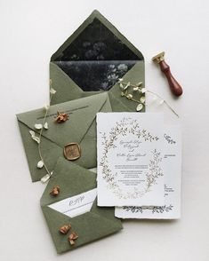 the wedding stationery is laid out on top of an envelope and some other items