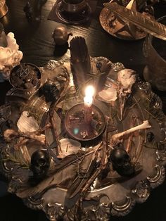 a candle that is sitting on top of a plate with spoons and other items