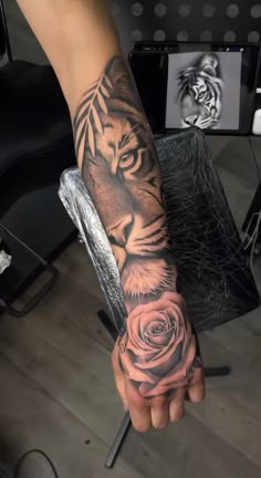 a person with a tiger and rose tattoo on their arm is holding a knife in the other hand