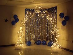 a room decorated with balloons, streamers and lights for a birthday party or celebration