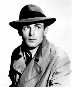 a man wearing a trench coat and hat