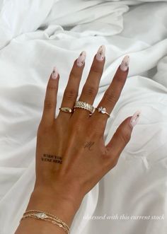 a woman's hand with two rings on her left and one ring on her right