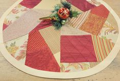 a close up of a patchwork table cloth with a flower on the center piece