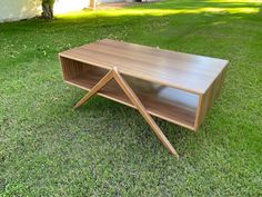 a wooden table sitting on top of a lush green field