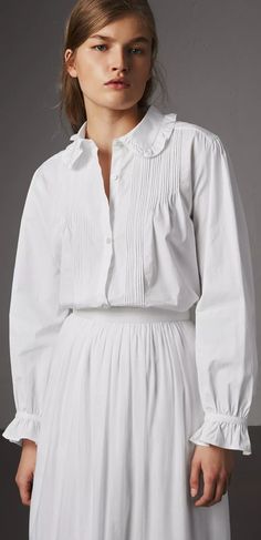 A feminine shirt by Burberry in light Italian-woven cotton. Textured with a finely pintucked front and subtle embroidery, the design features ruffles at the collar and cuffs. Gathering at the sleeve and back add volume. Burberry Clothes Women, Burberry Clothes, Blouses For Work, Subtle Embroidery, Feminine Shirts, United State, White Cotton Dress, Designer Shirts, Clothes Women