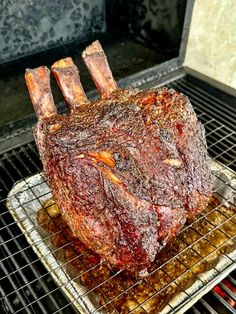 a large piece of meat sitting on top of a metal rack in an open oven