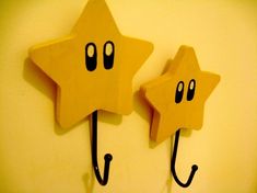 two wooden star shaped hooks hang on the wall, one with eyes and nose drawn on it