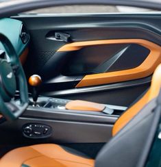 the interior of a sports car with orange and black leather