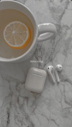 an apple airpods sitting on top of a marble counter next to a cup of coffee