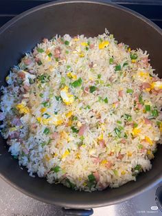 rice and vegetables are mixed together in a pan on top of the stove burner