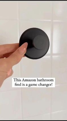 a person holding an object in their hand with the caption, this amazon bathroom find is a game change