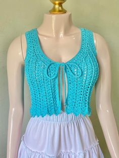 a mannequin wearing a blue crochet top and white dress with ruffles