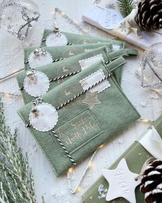 three green towels sitting on top of a table next to pine cones and christmas decorations