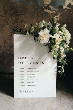 an order of events sign with flowers on it