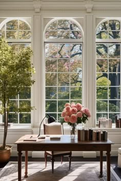 a living room filled with lots of windows next to a wooden table and white chairs