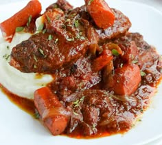 a white plate topped with meat and mashed potatoes