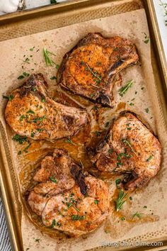 three pieces of chicken on a baking sheet with herbs and seasoning sprigs