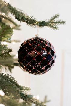 a black ornament hanging from a christmas tree