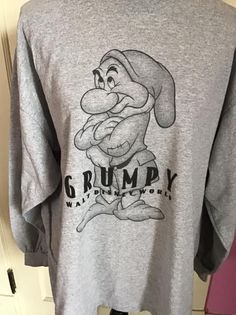 "Vintage 1990's Y2K long sleeve Tee Shirt with *GRUMPY* on it. Gray in color. Made of 90% Cotton and 10% Polyester. Tagged size XL. Go by the measurements below. *MORE INFORMATION BELOW* CONDITION: No issues noted. MEASURES: Chest/Bust~48\" Bottom edge~52\" Sleeve length~21\" Shoulder seam to shoulder seam~23\" Back of collar to bottom~29\" *WE APOLOGIZE~BUT WE NO LONGER SHIP TO GERMANY, ITALY OR SPAIN. IF ORDERS COME IN FROM GERMANY, ITALY OR SPAIN, WE WILL HAVE TO CANCEL THEM AND REFUND YOUR M Retro Long Sleeve Tops With Screen Print, Retro Long Sleeve Pre-shrunk Sweatshirt, Winter Long Sleeve Graphic Shirt, Retro Long Sleeve Shirt For Streetwear, 90s Long Sleeve Graphic T-shirt, 90s Graphic Print Long Sleeve T-shirt, Oversized Long Sleeve Shirt With Screen Print, Casual Long Sleeve Shirt With Screen Print, Gray Long Sleeve Pre-shrunk T-shirt