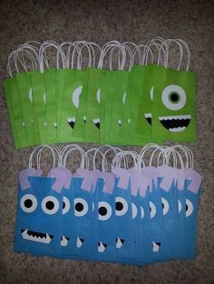 paper bags with monster faces on them are lined up in the shape of small monsters