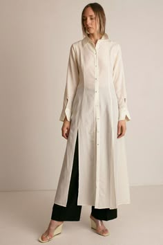 Maxi shirt dress in ivory lyocell poplin. Shirt collar. Front placket with fabric covered buttons. Princess seaming at front and back. Full skirt with front slits at hem. Long sleeves with front facing cuff. Keyhole closure at cuff. Slightly sheer. Ella is 6' tall, 35" bust, 26" waist, 36" hip, and is wearing a size S. Long Shirt Pattern, Long Button Down Shirt Outfit, Long Shirt Ideas, Long Shirt Dress Outfit, Shirt Dress Designs, Long Tops Designs, Long Shirt Design, Long Shirts For Women, Long Dress Shirt