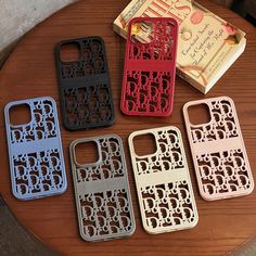 four cell phones sitting on top of a wooden table next to a box of cookies