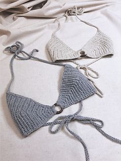 three crocheted bikinisuits laying on top of a white sheet covered bed