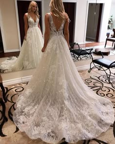 a woman standing in front of a mirror wearing a wedding dress with sequins