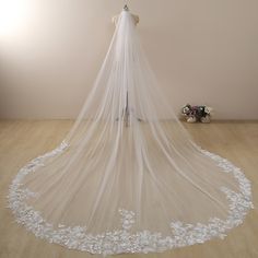 a wedding veil with white flowers on it