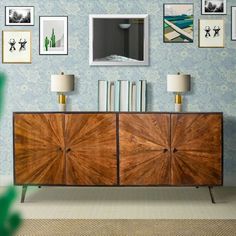 a living room with blue wallpaper and pictures on the wall, including a large wooden cabinet