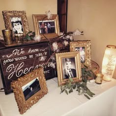 a table topped with framed pictures and flowers